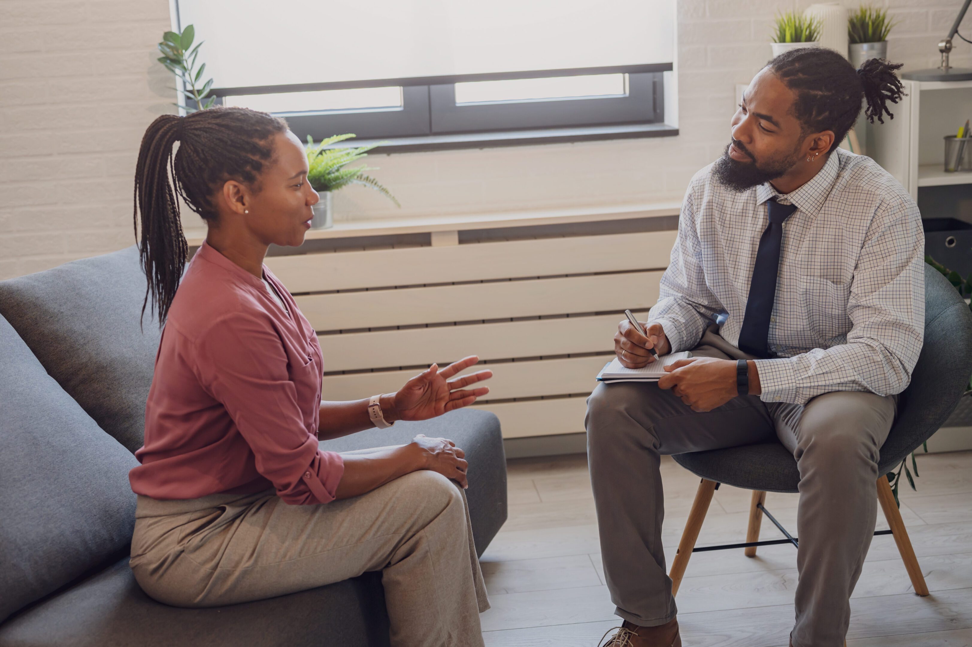A psychotherapist session with a patient. African-American women and men have a meeting.