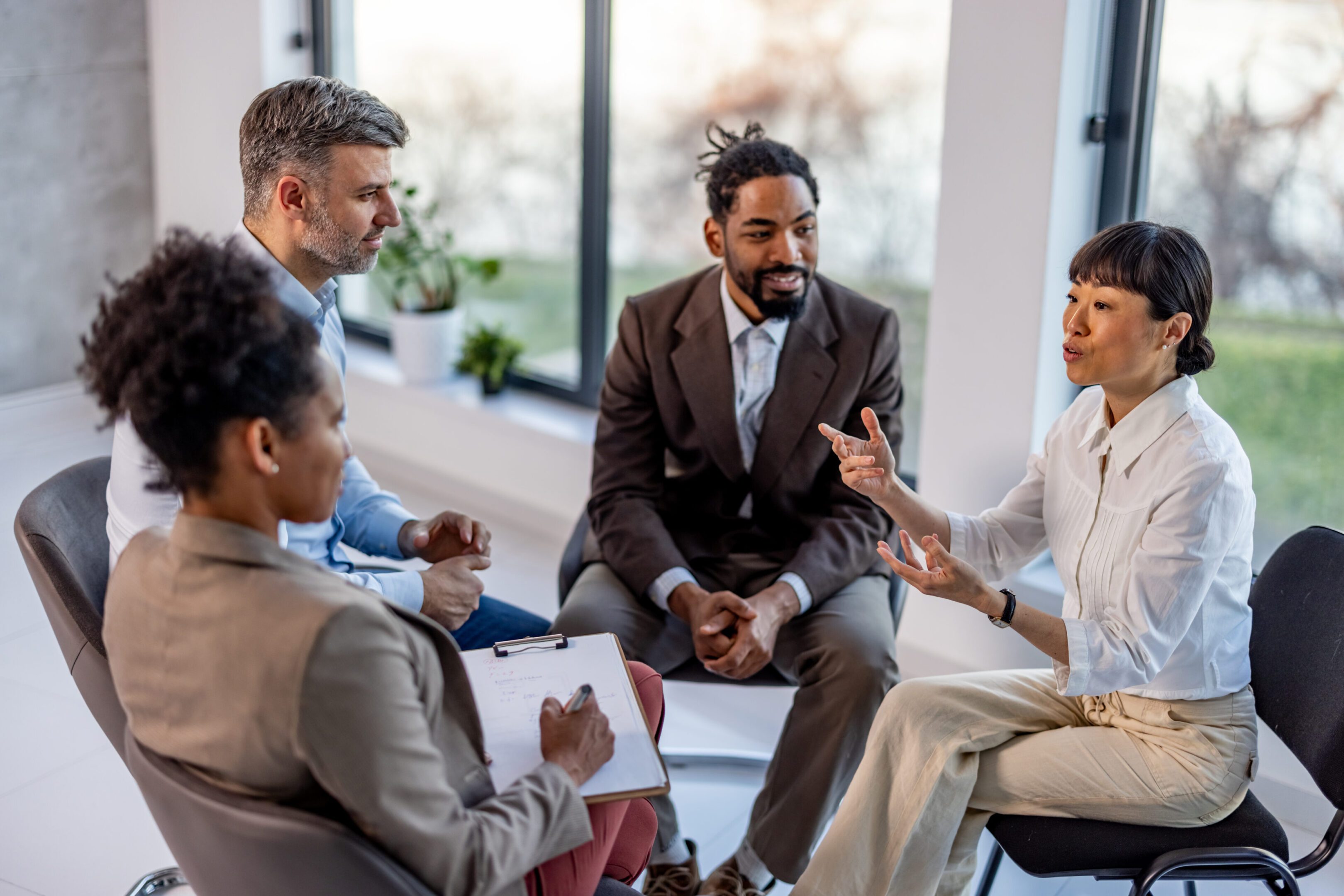 Happy businesswomen communicating next to her colleagues in a modern office space.